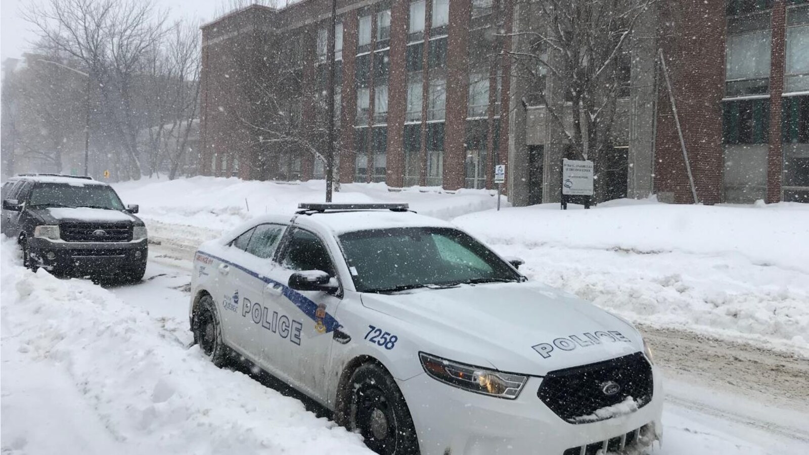 Une voiture du Service de police de la Ville de Québec est stationnée devant le Quebec High School.