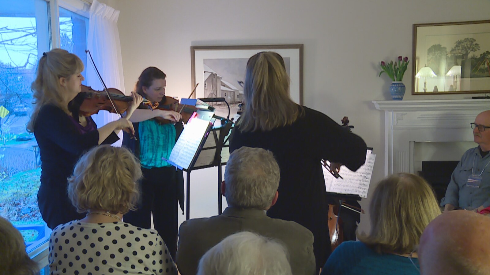 Un orchestre de chambre joue dans le salon d'une résidence privée.