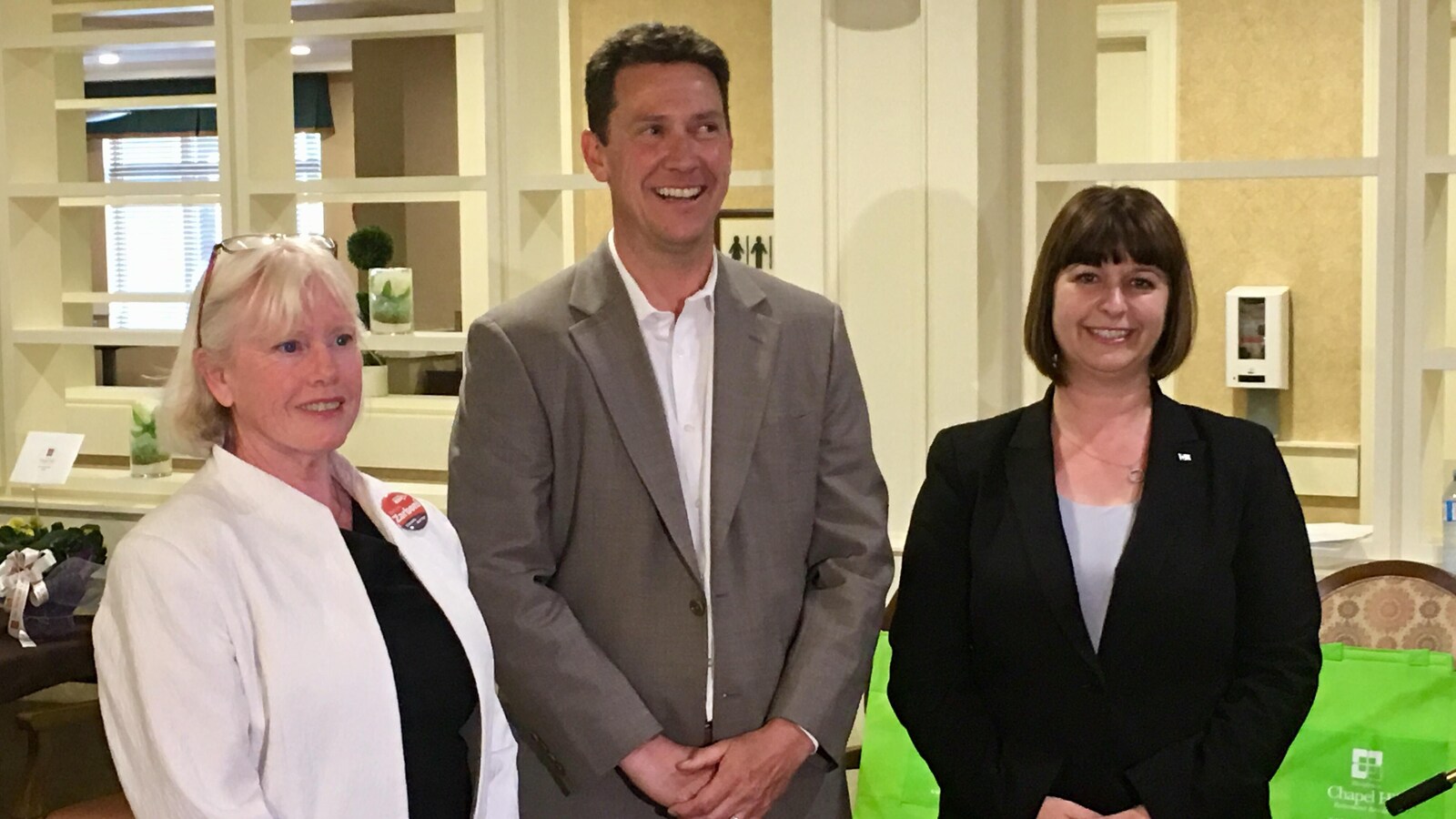 Photo de deux femmes et d'un homme qui posent pour la caméra.