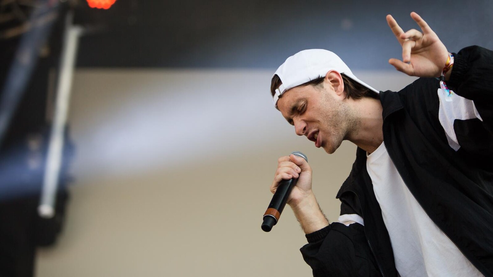 Le rappeur Loud pendant un concert, une main dans les airs.