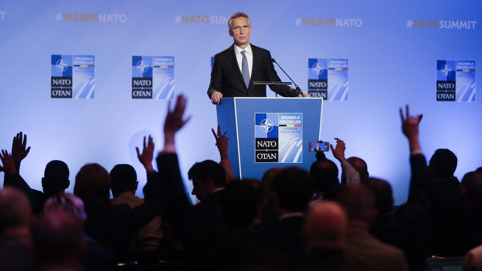 Le secrétaire général de l’OTAN, Jens Stoltenberg, debout derrière un podium durant une conférence de presse à la veille du sommet annuel de l’Alliance, à Bruxelles.