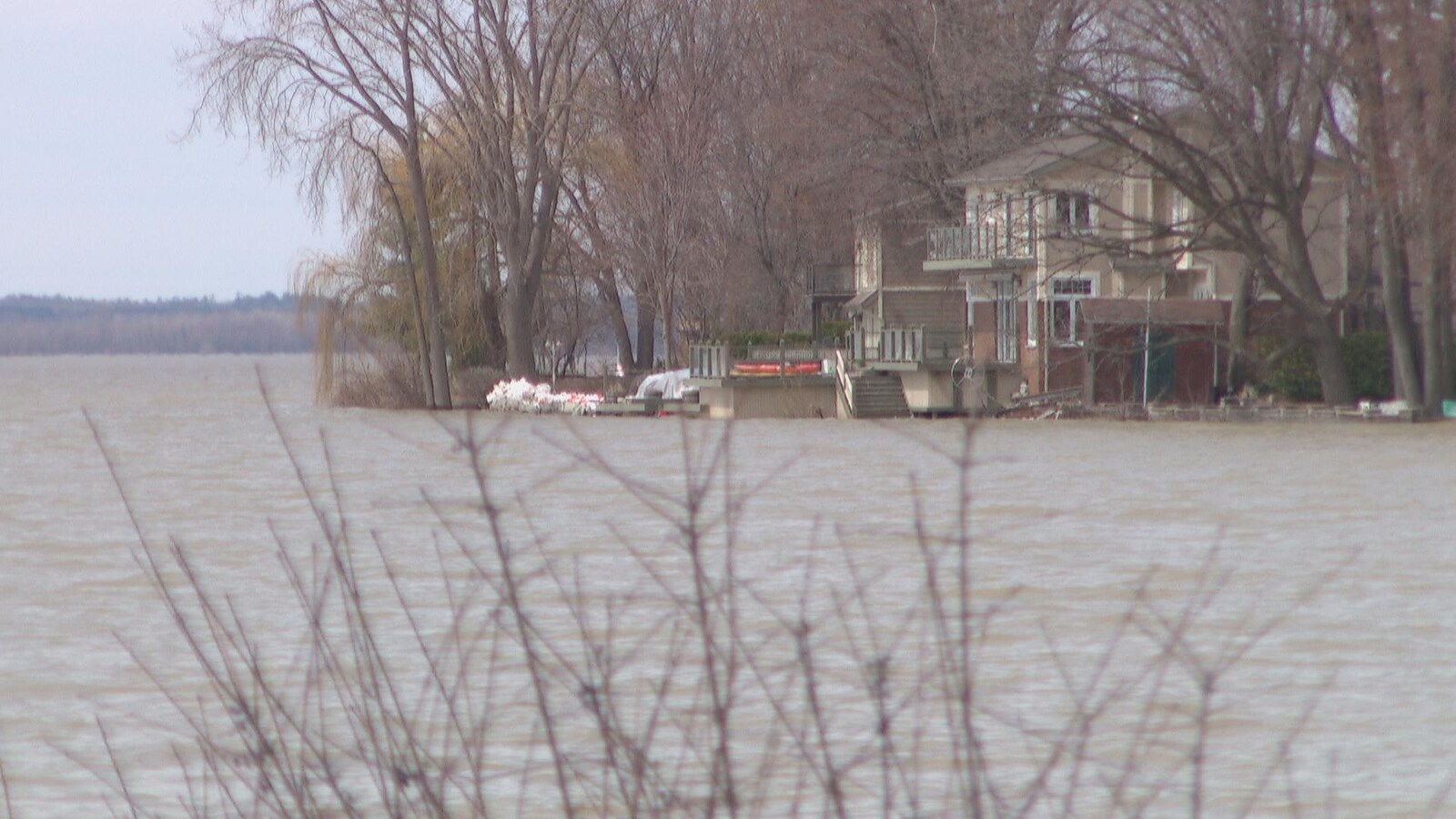 De l'eau se rapproche d'une maison située aux abords de la rivière des Outaouais.