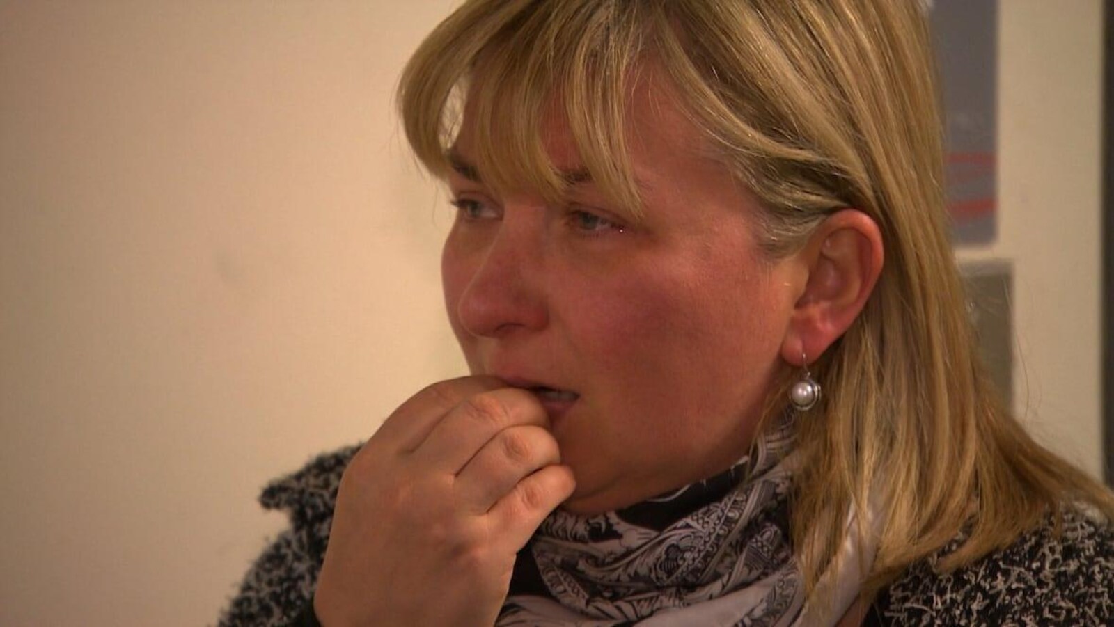 Oxana Berent a les yeux embués et porte la main à son visage.