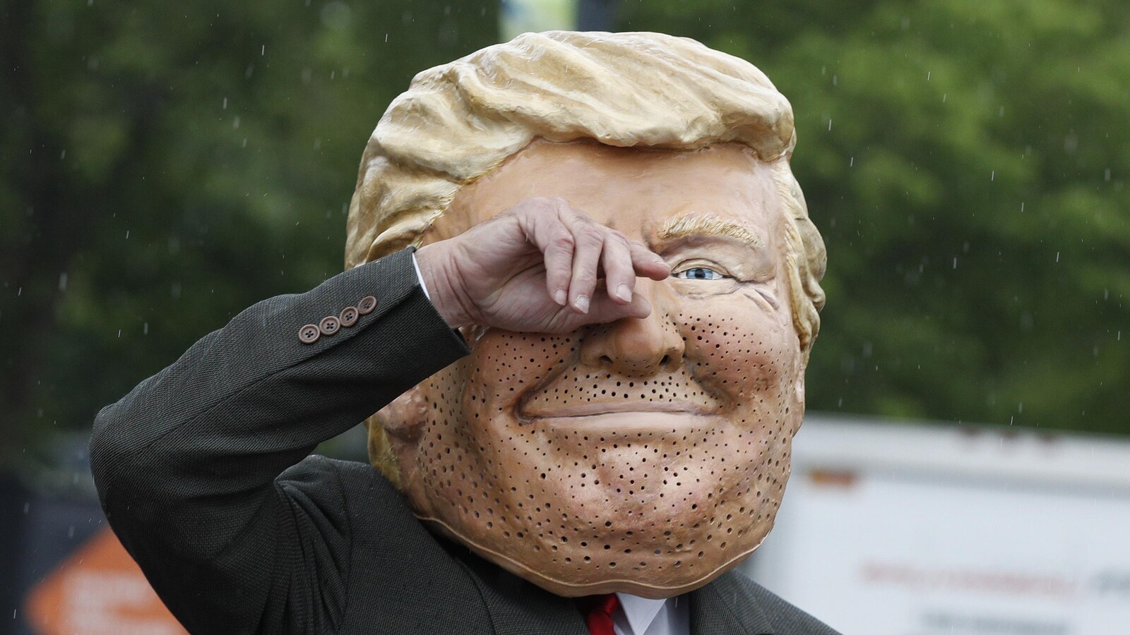 Un membre d'Oxfam manifeste en marge du Sommet du G7, à Québec, vêtu d'une tête géante du président américain Donald Trump.