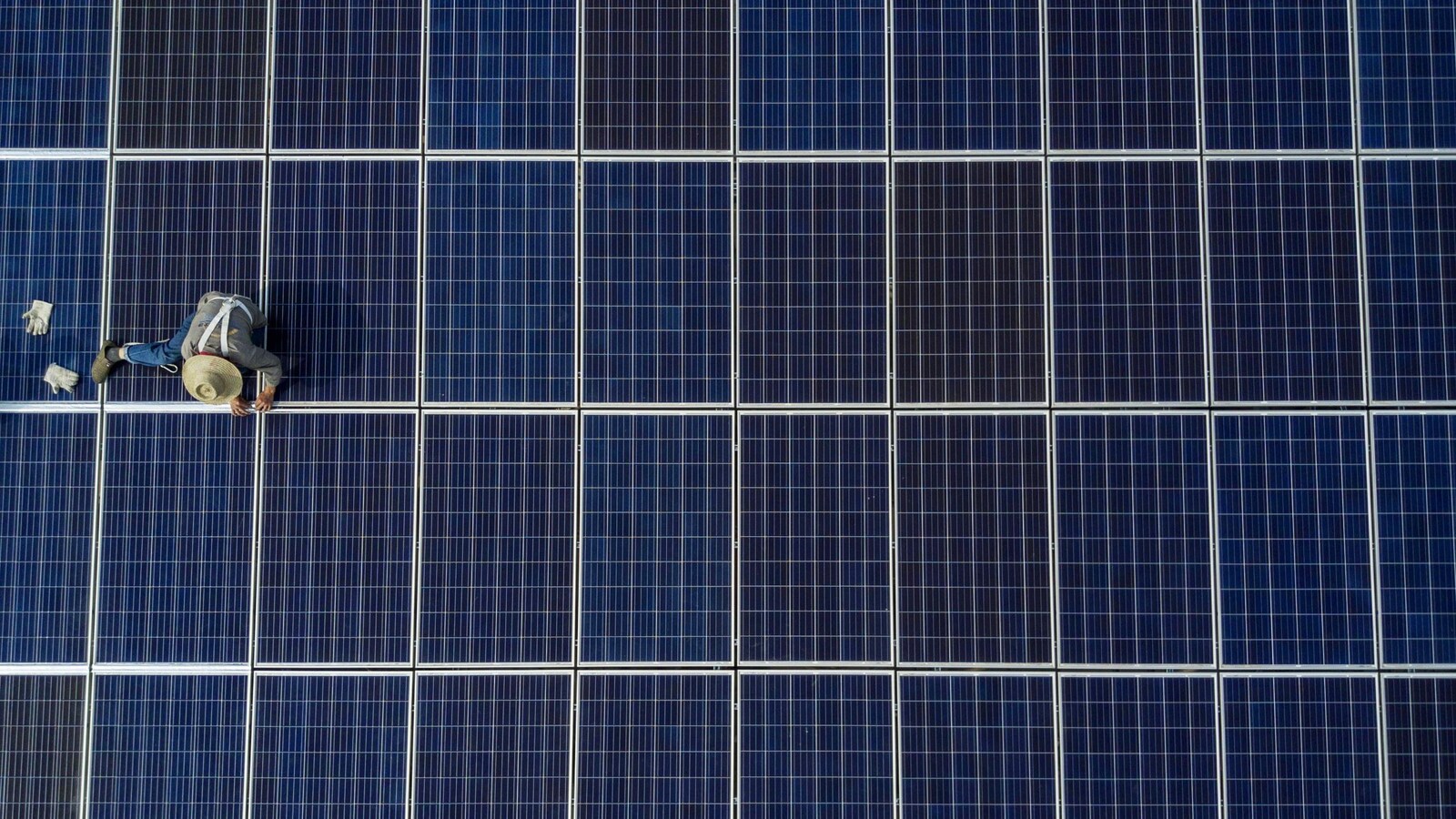 Un ouvrier chinois pose des panneaux solaires au sommet d'un immeuble de 47 étages à Wuhan.