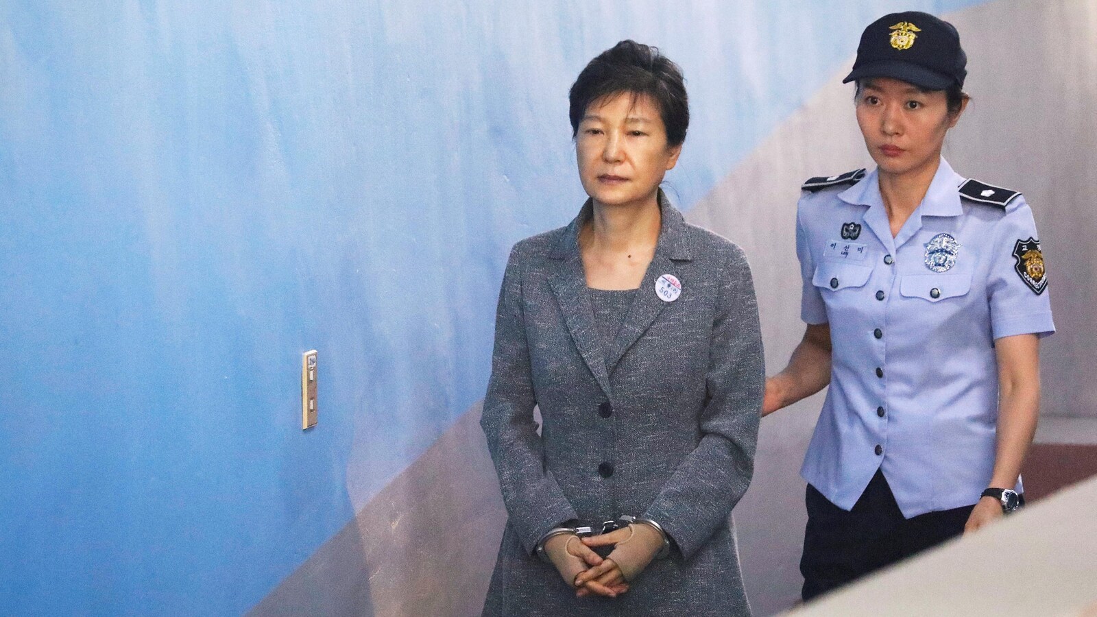 L'ancienne présidente sud-coréenne Park Geun-hye arrive en cour escortée par une policière, à Séoul, le 25 août 2017.