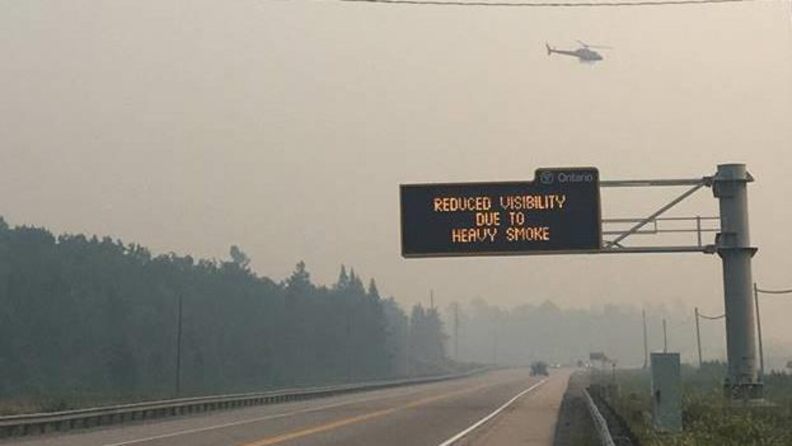 Un signal routier indiquant une visibilité réduite en raison de la fumée