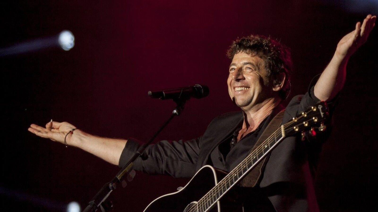 Le chanteur Patrick Bruel salue la foule sur les Plaines présente malgré la pluie.