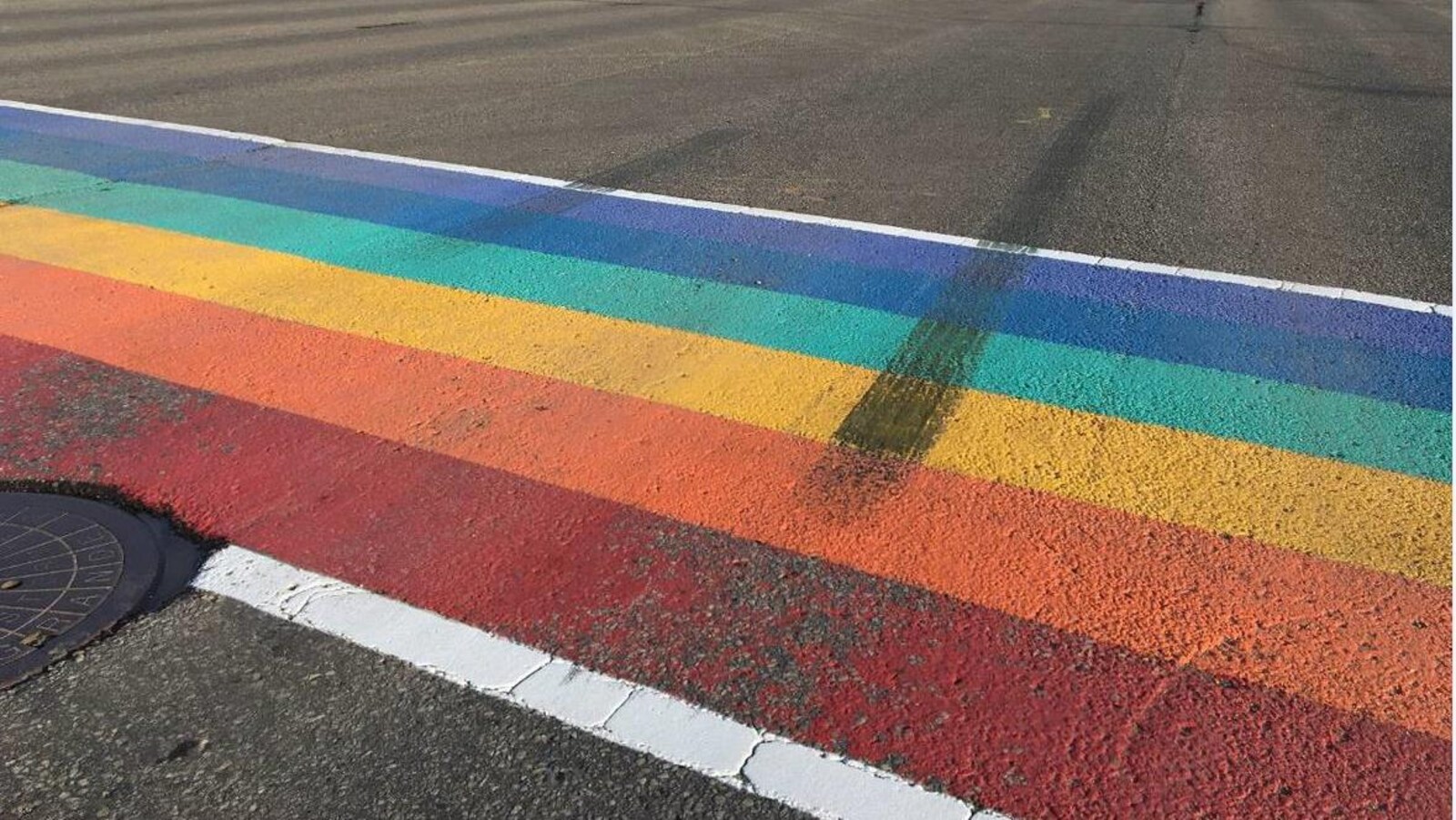 Des marque de pneus sur un passage piétons arc-en-ciel