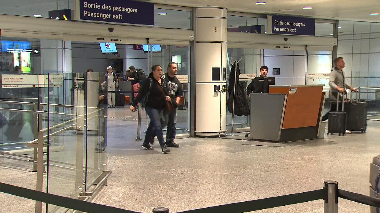 Des gens sortent par la sortie des passagers à l'aéroport Montréal-Trudeau.