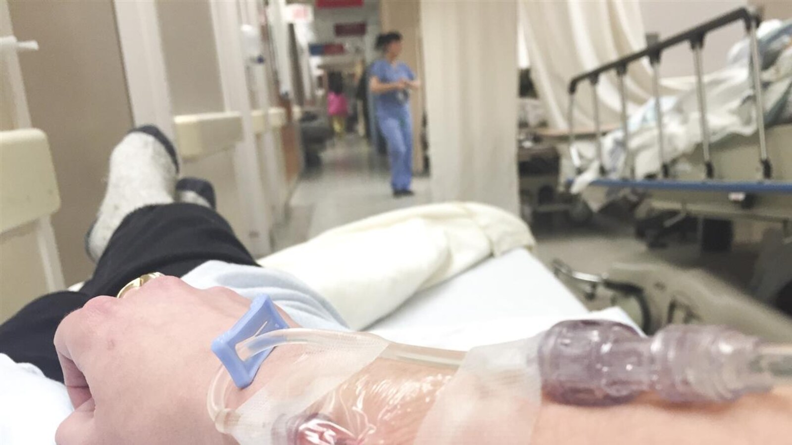 Une patiente allongée sur une civière dans le corridor de l'urgence d'un l'hôpital