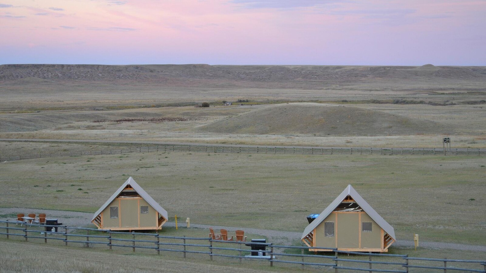 Vue sur deux cabanes dans les prairies, à la tombée du jour.