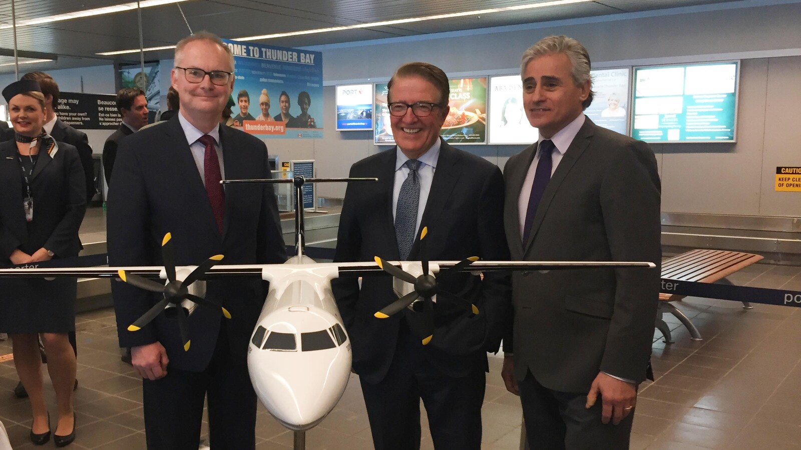 Trois hommes posant pour une photo derrière la maquette d'un avion.