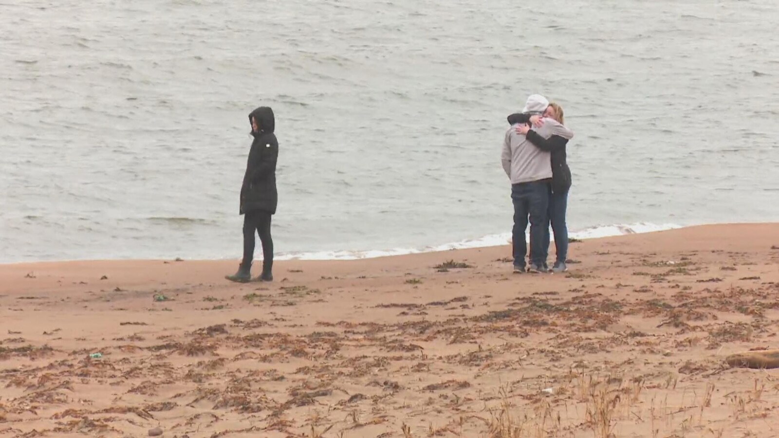 Trois personnes sur la côte.