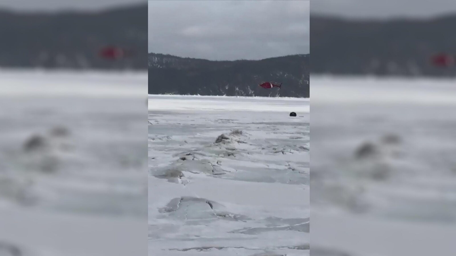 Une tente au loin sur les glaces avec un hélicoptère qui vole au-dessus.