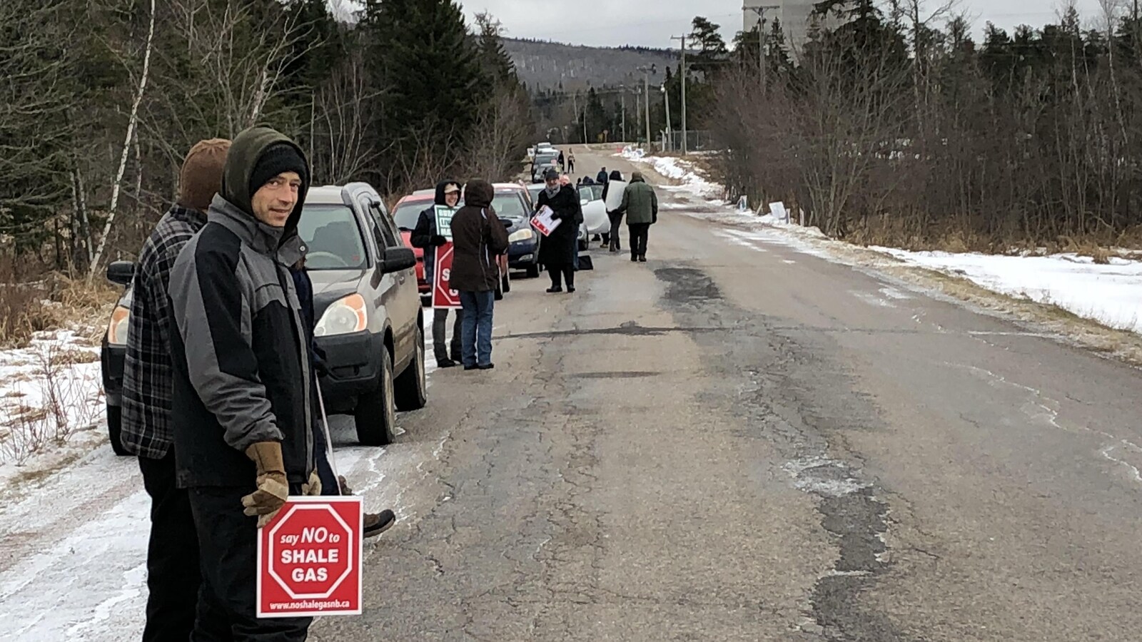 Le groupe de manifestants s'étire le long de la route.