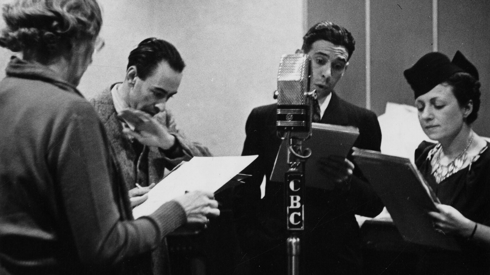 Dans un studio de radio, autour d'un microphone sur pied, la comédienne Jeanne
Maubourg, l'auteur Robert Choquette, les comédiens Clément Latour et Berthe Lavoie.