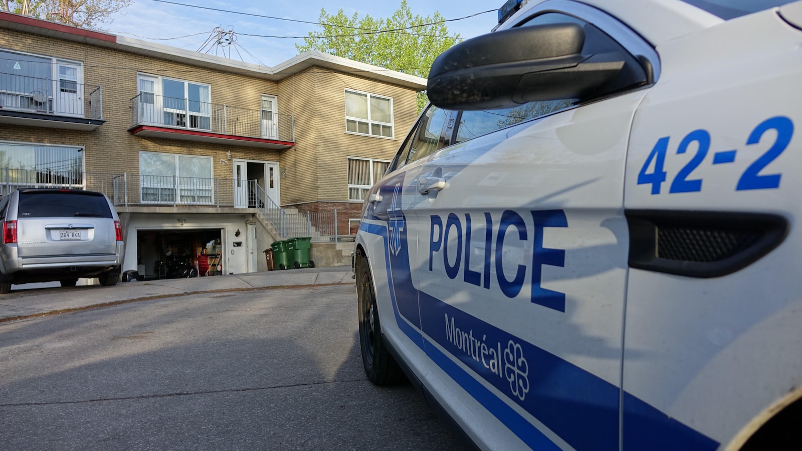 Une voiture de police devant le domicile d'un suspect