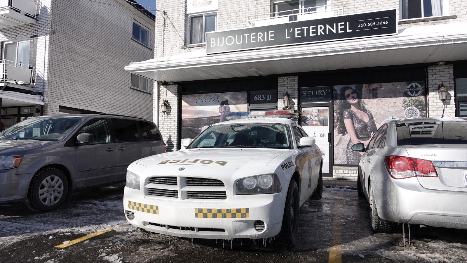 Une voiture de la Sûreté du Québec est stationnée devant la bijouterie.