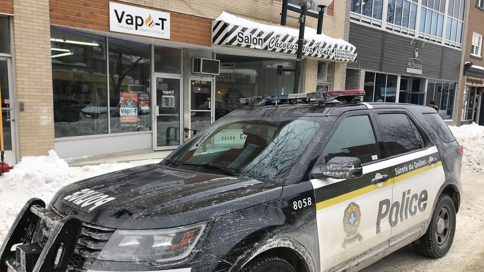 Une voiture de la Sûreté du Québec est stationnée devant un commerce nommé Vapo-T.