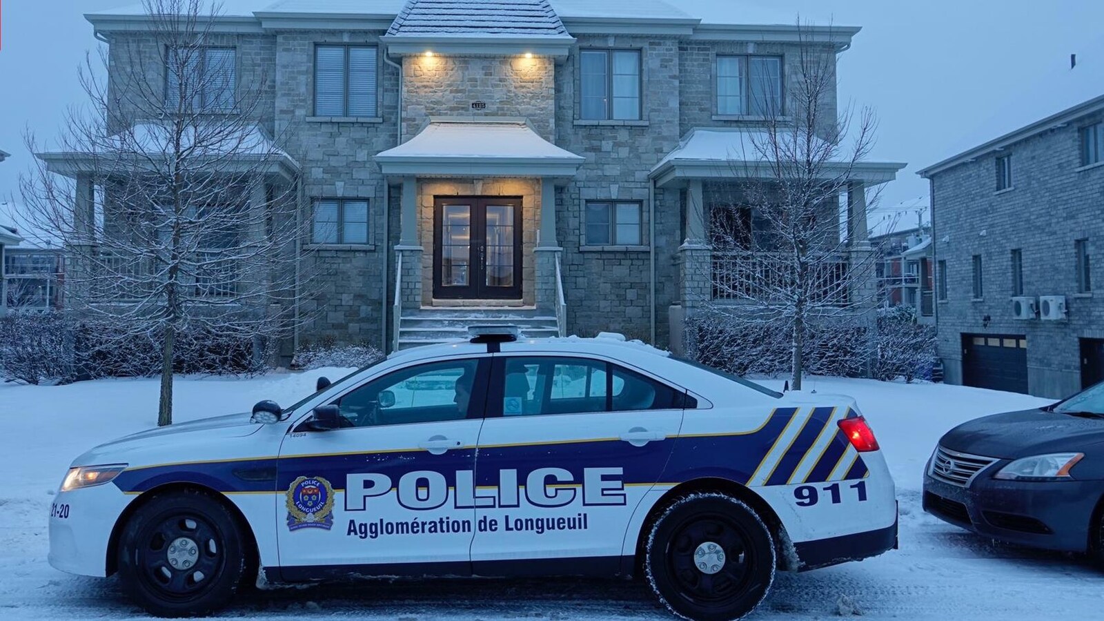 Une voiture de police de l'agglomération de Longueuil stationnée dans la rue.