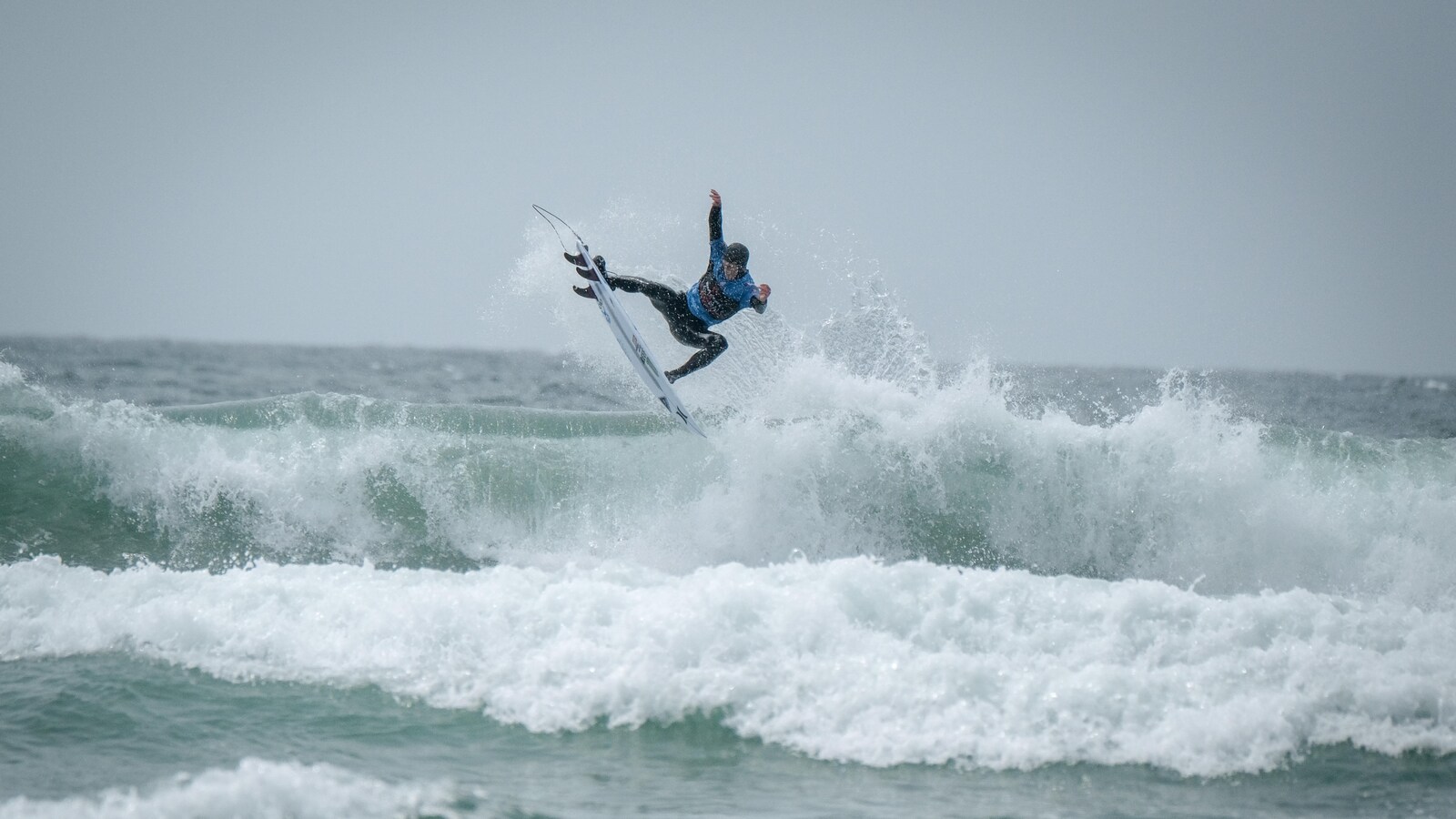 Peter Devries, champion canadien de surf 2019, est debout sur sa planche en haut d'une vague qui se brise à Tofino.