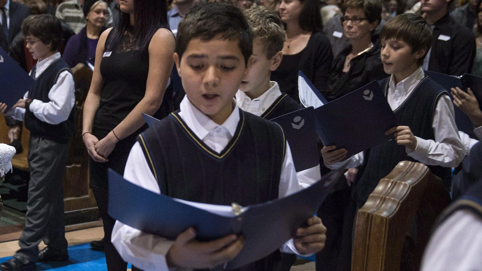 Les Petits Chanteurs chantent lors des funérailles du comédien Paul Buissonneau.
