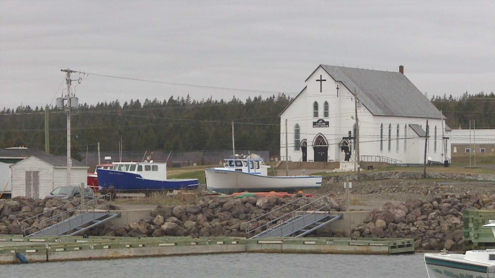 Église et bateaux à Petit-de-Grat, en Nouvelle-Écosse.