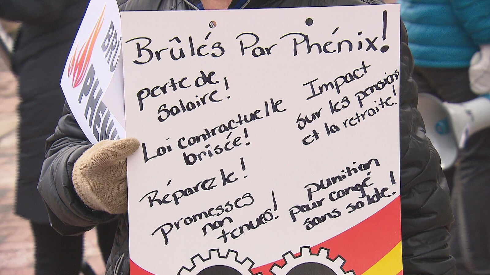 Pancarte d'un manifestant mécontent du système de paye Phénix.