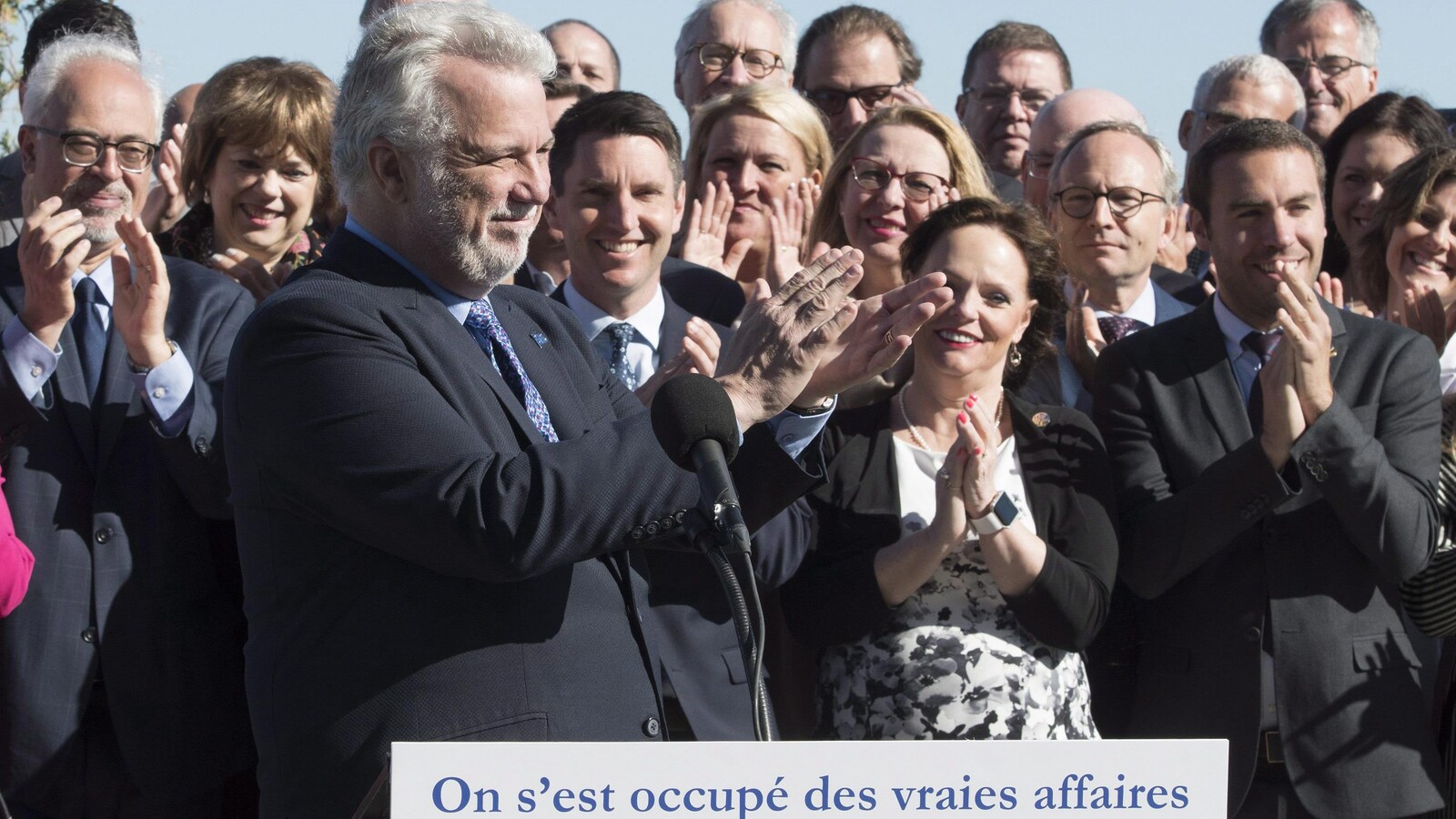 Philippe Couillard applaudit, à l'instar de nombreux députés libéraux prenant place derrière lui, dont Carlos Leitao, Hélène David, André Fortin, Lucie Charlebois ,Lise Thériault, Martin Coiteux et Stéphanie Vallée.
