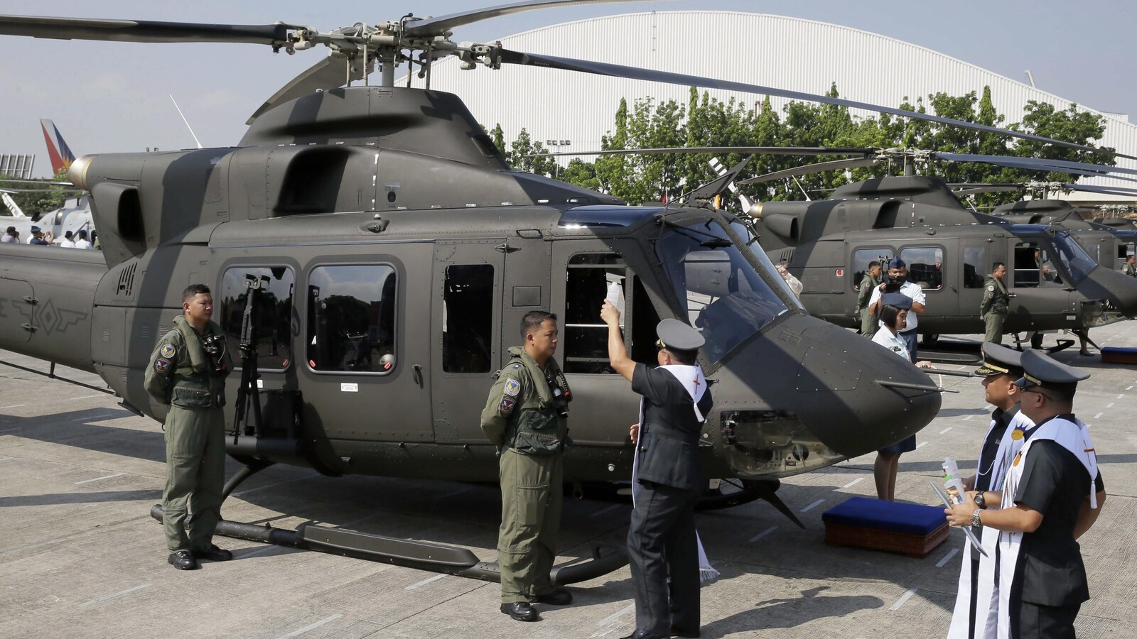Un aumônier militaire philippin asperge d'eau bénite, en 2015, un des huit appareils alors acquis de Bell Helicopter