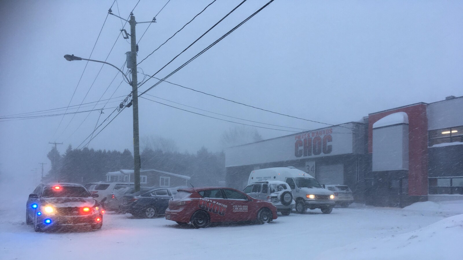 Une voiture de police stationnée devant un commerce.