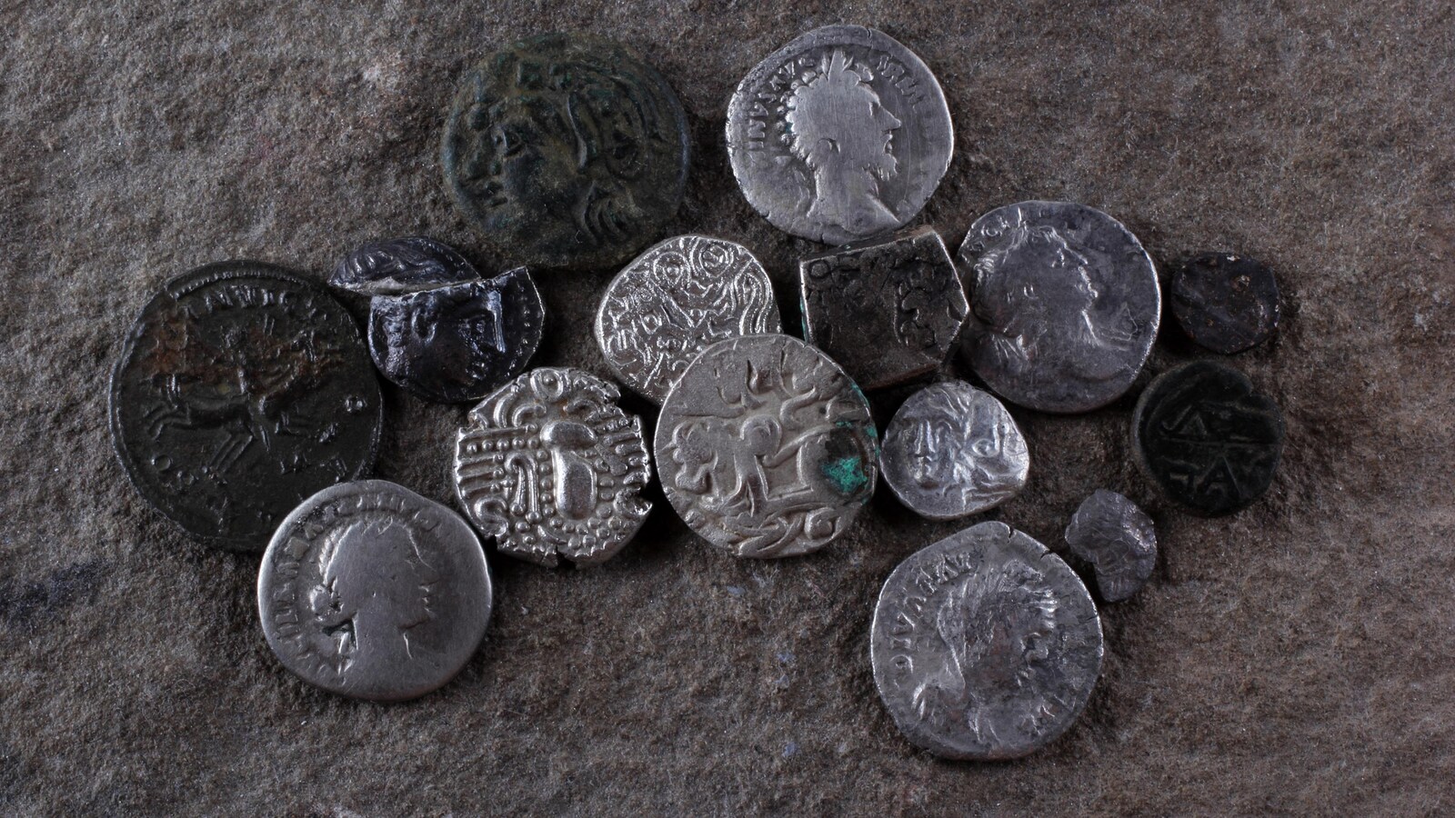 Des pièces de métal antiques déposées sur le sol.