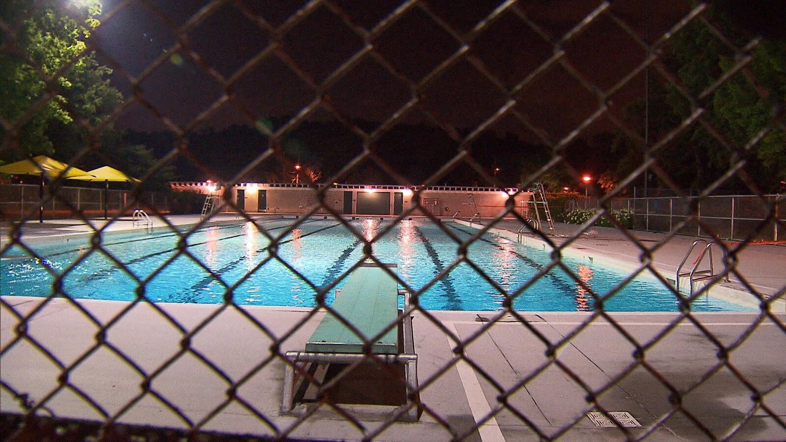 Une piscine est calme et fermée après ses heures habituelles d'ouverture.