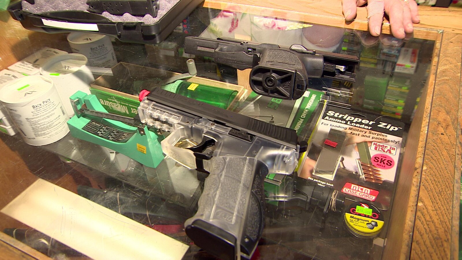 Deux pistolets l'un à côté de l'autres sont entreposés sur le comptoir d'un magasin d'armes à feu.