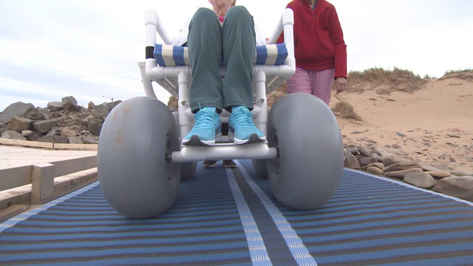 Roues d'un fauteuil roulant adapté pour rouler sur le sable des plages.