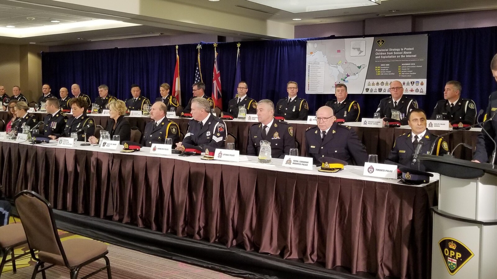 Des policiers assis derrières des tables.