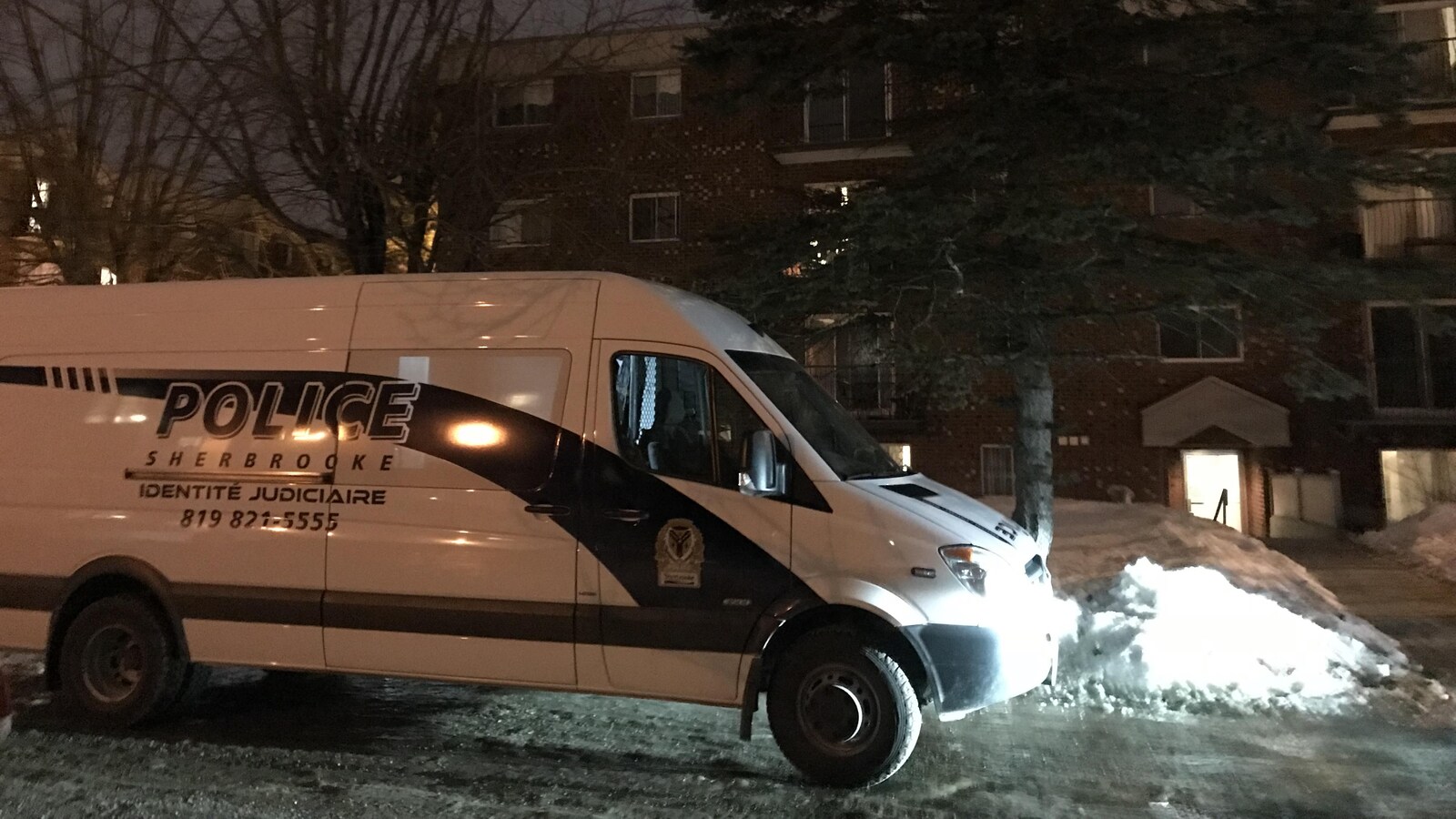 Une voiture de l'identité judiciaire de la police de Sherbrooke est stationnée devant un logement.