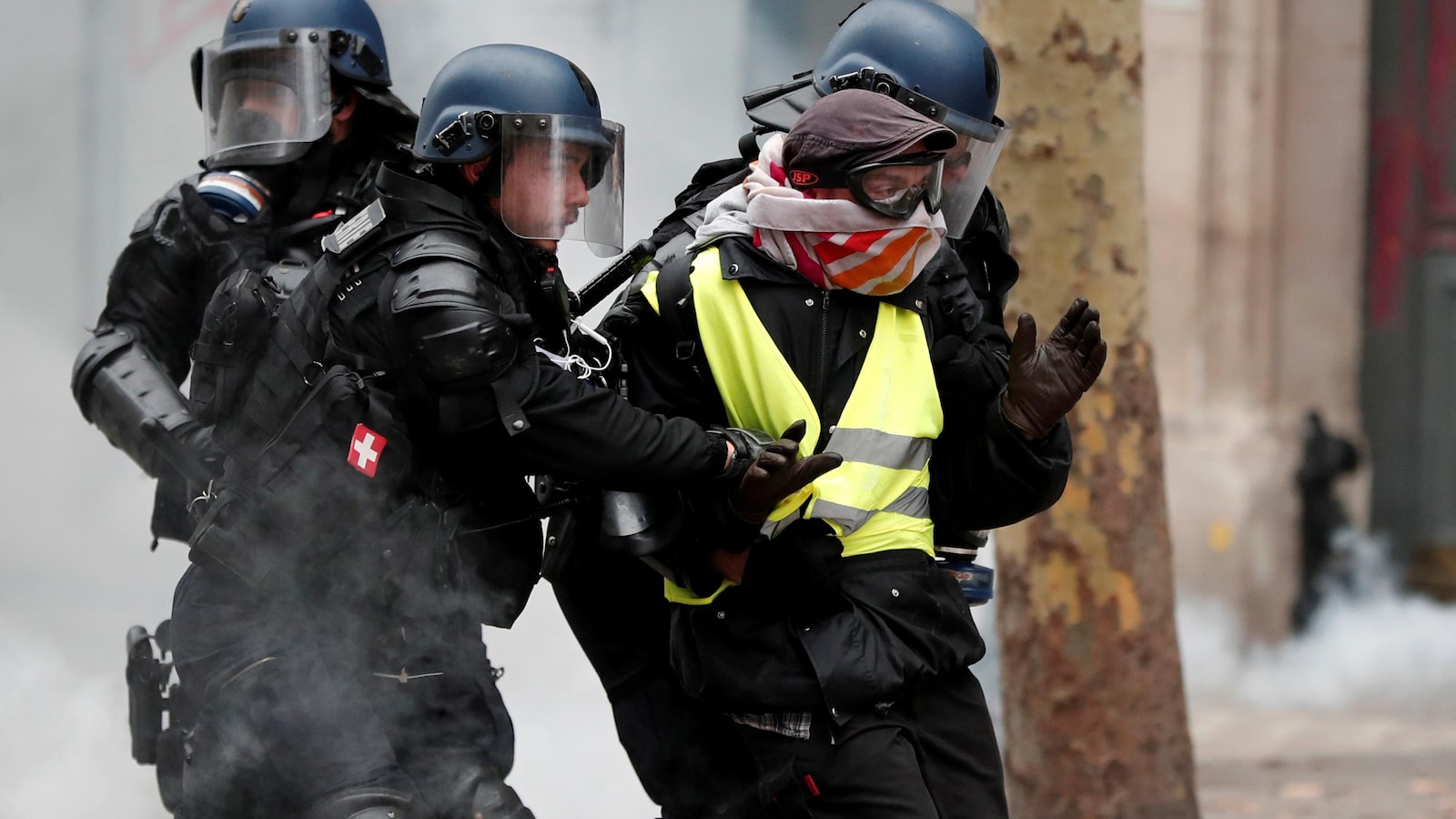 Des policiers retiennent un manifestant.