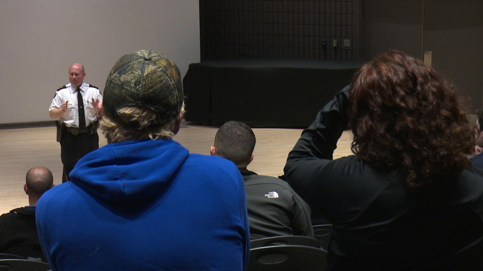 Un agent de la PPO s'exprime dans un amphithéâtre.