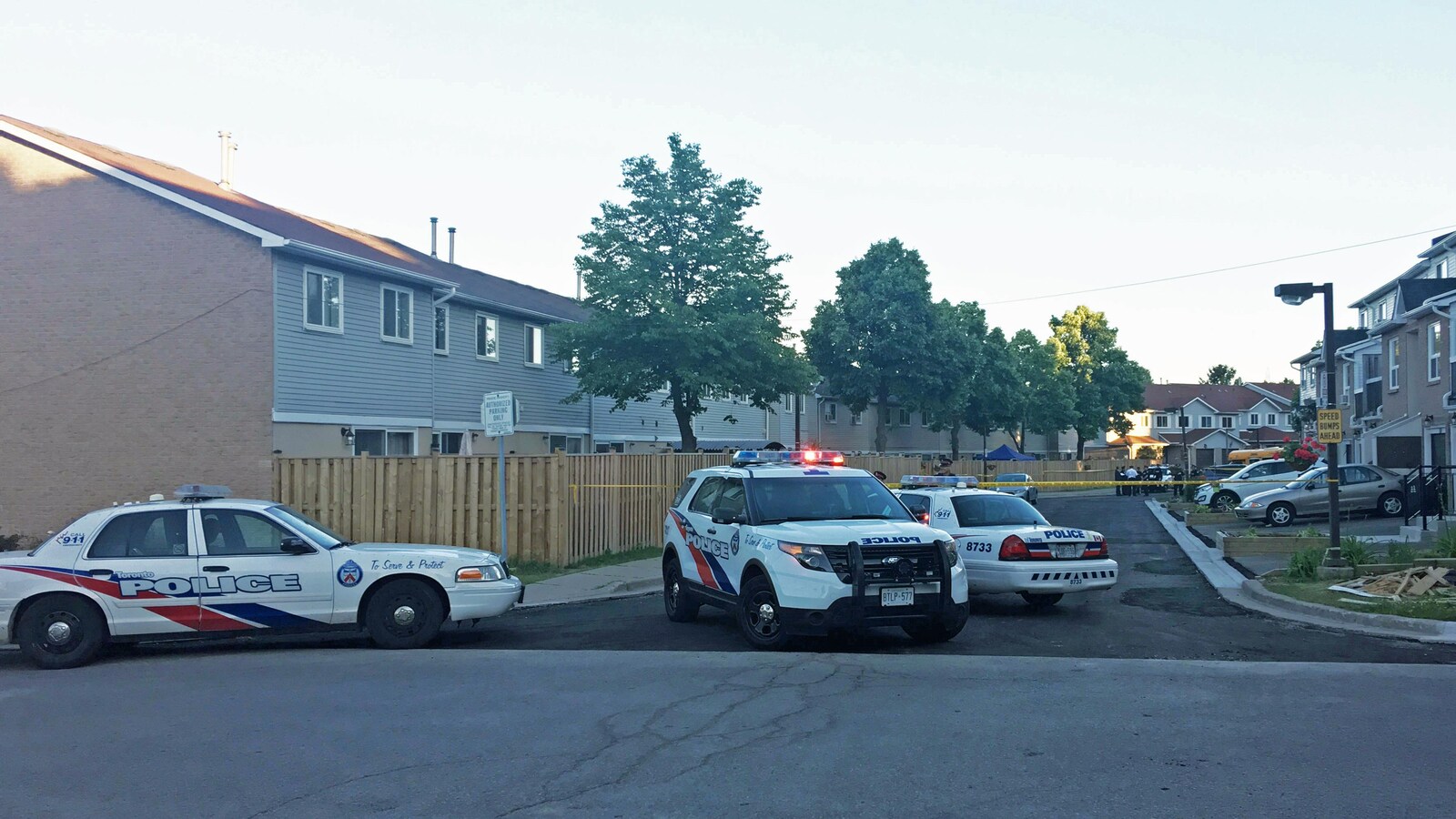 Trois véhicules de police bloquent une rue.