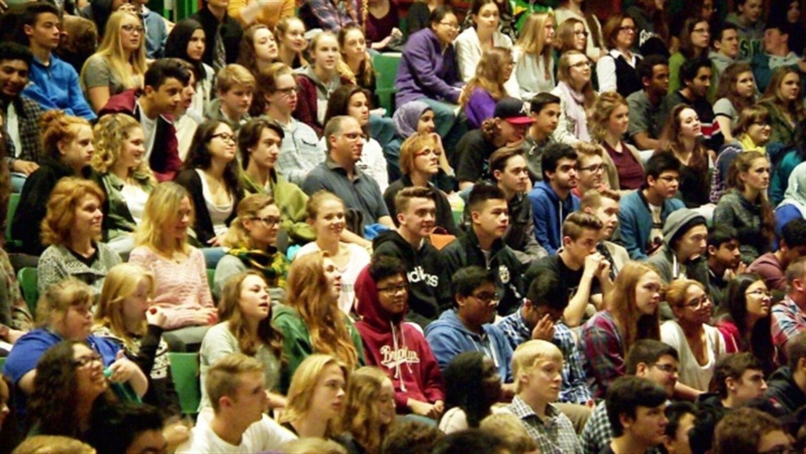 Une foule assise dans une salle.