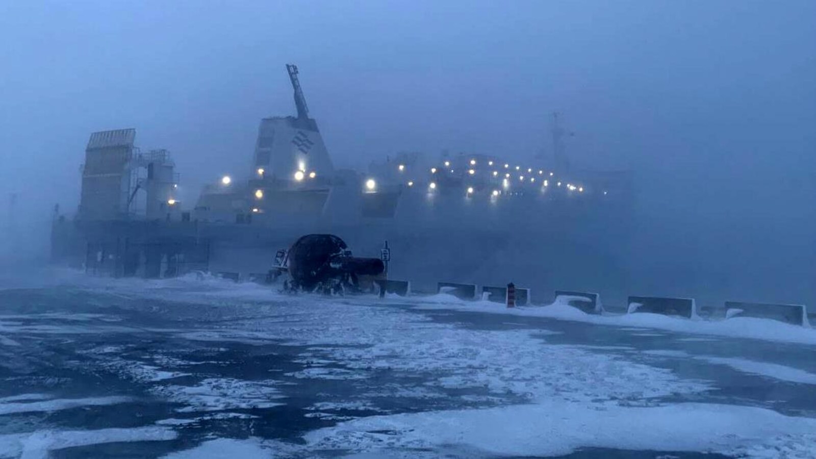 Le grand navire amarré à son quai se fond dans les bourrasques de neige et de vent.