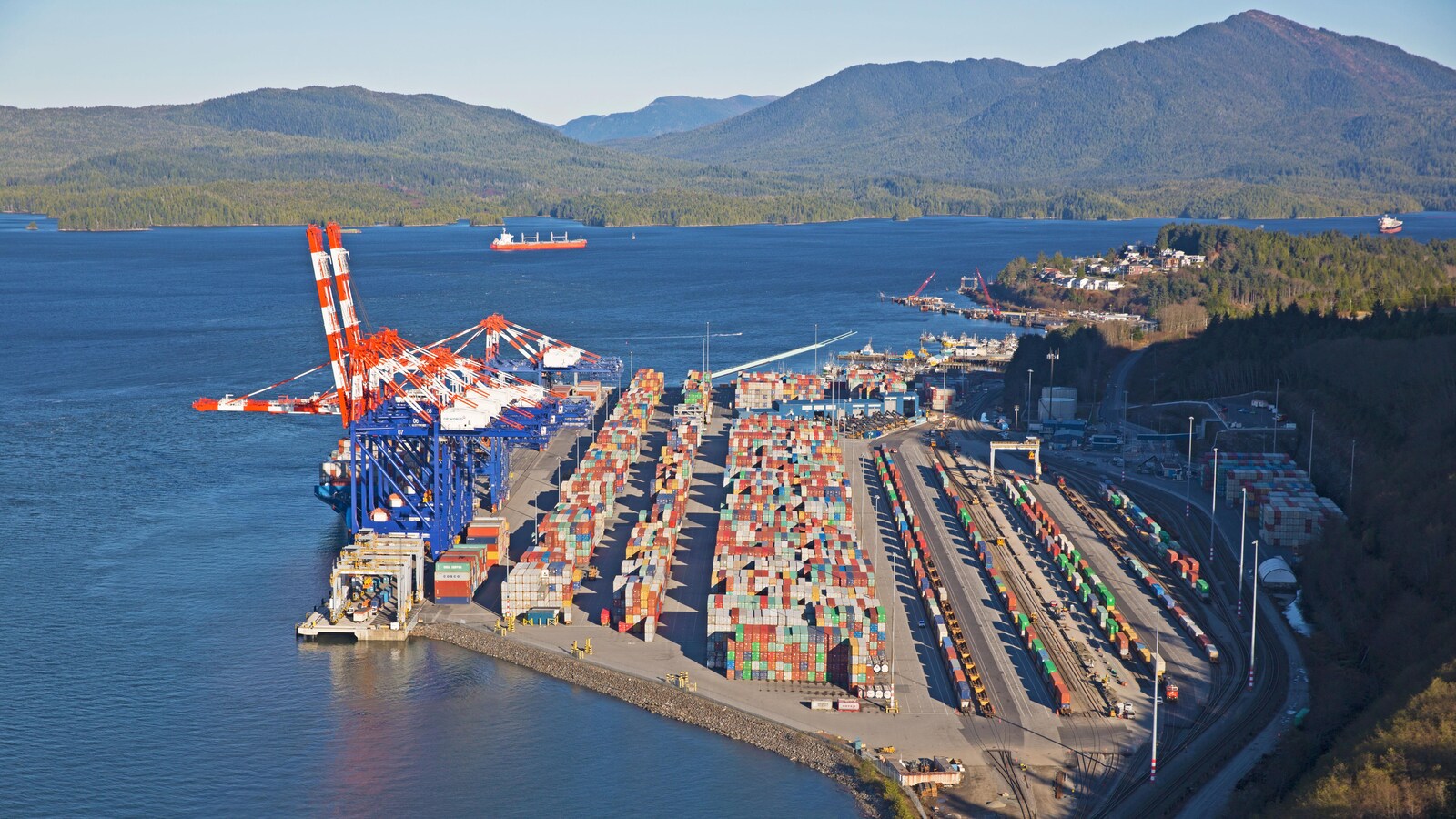 Vue aérienne du terminal Fairview, avec les grues du port, des rangées de conteneurs et des trains en chargement.