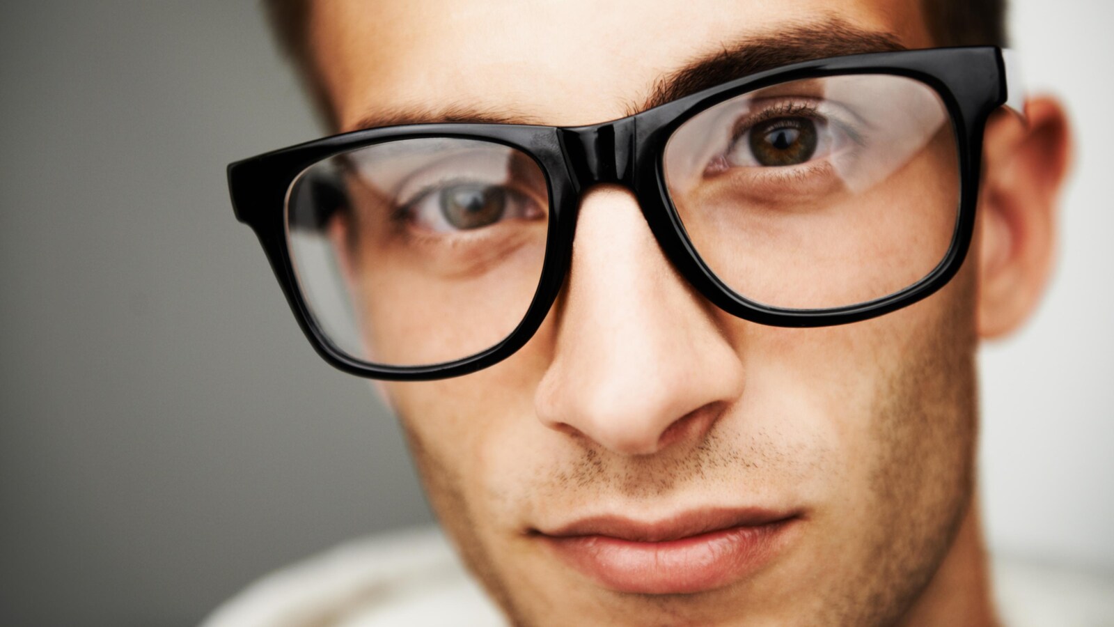 Gros plan sur le visage d'un homme qui porte des lunettes.