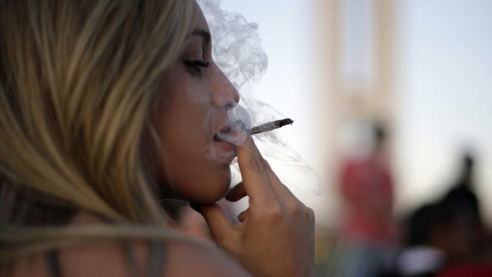 Une femme fume un joint.