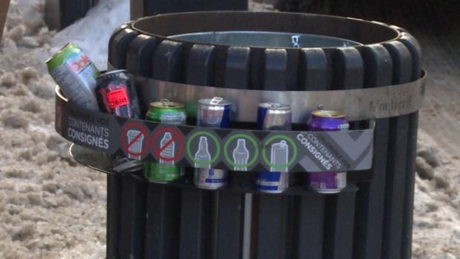 Une poubelle autour de laquelle est installé un support contenant plusieurs bouteilles consignées.
