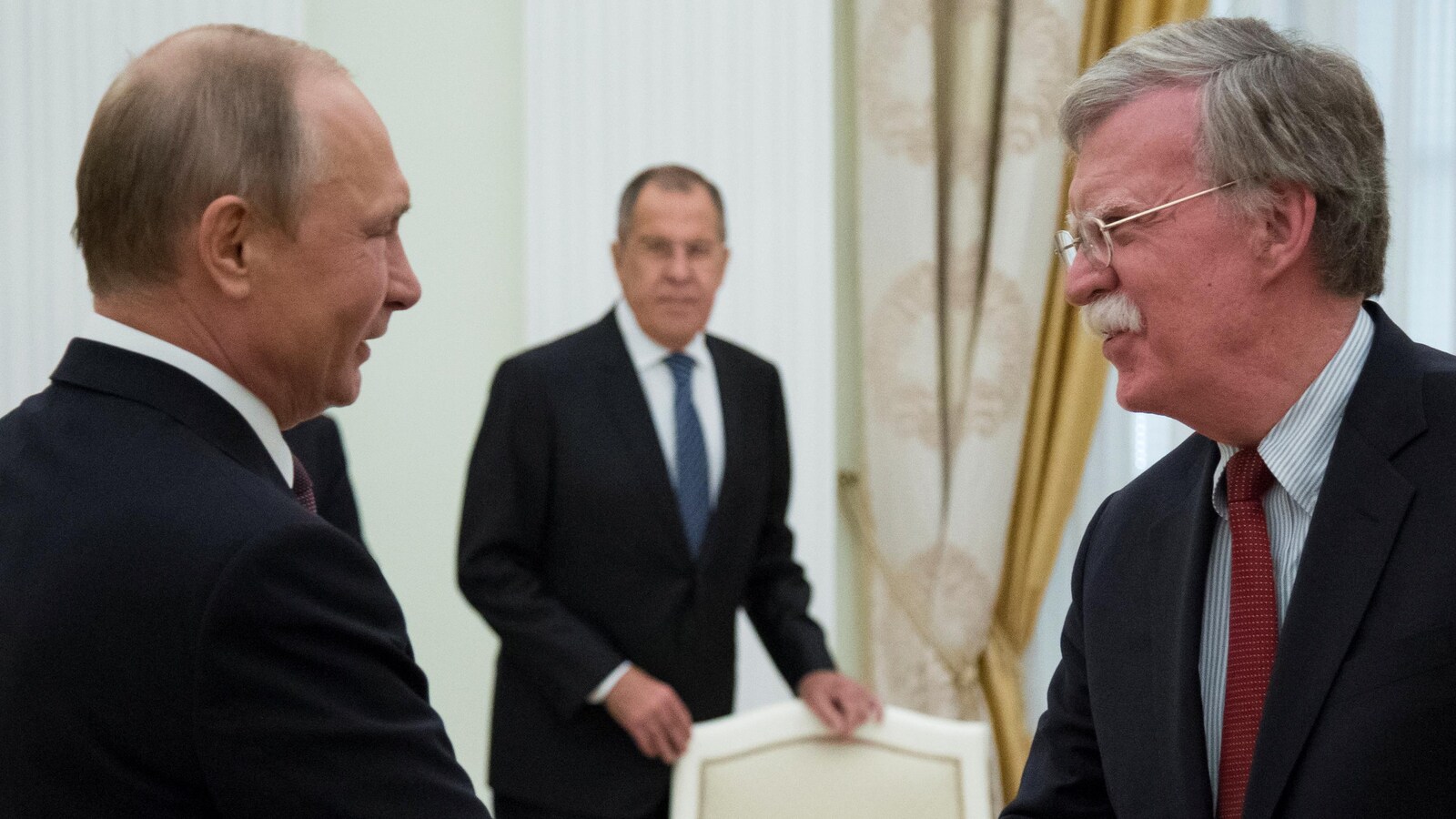 Vladimir Poutine serre la main à John Bolton.