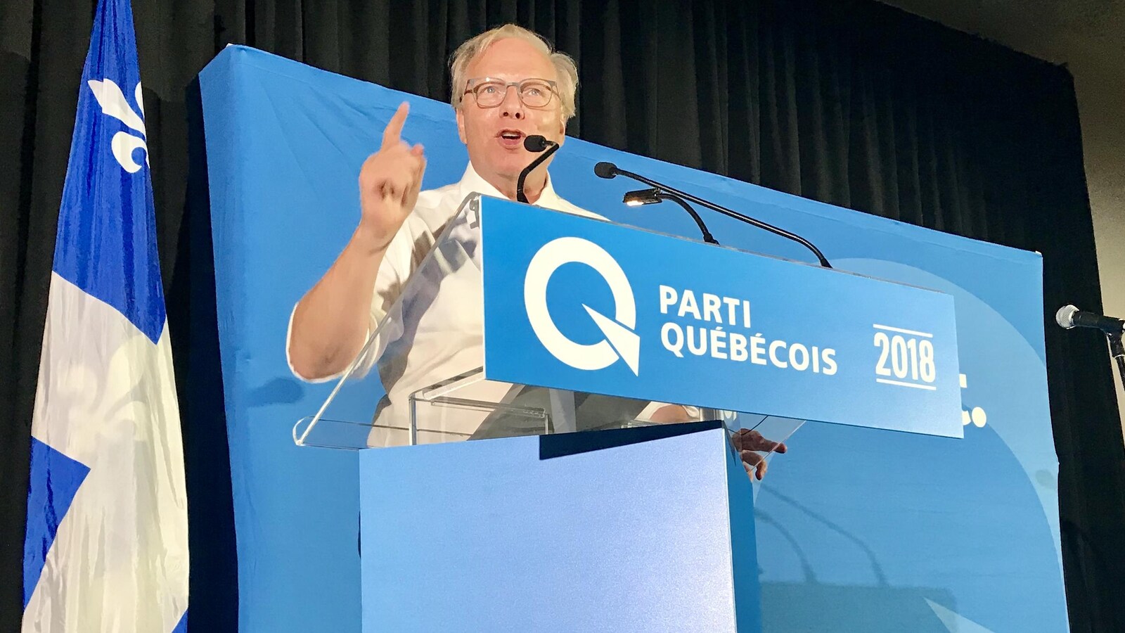 Jean-François Lisée, debout derrière un podium, brandissant l'index en parlant.