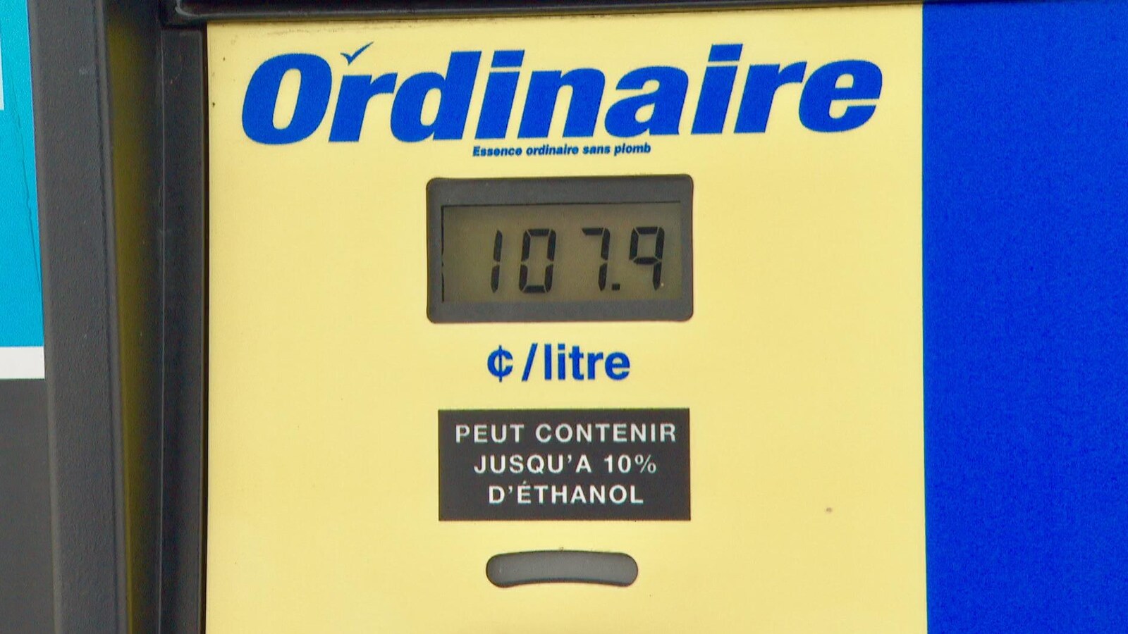 Une pompe d'essence ordinaire sans plomb qui indique le prix de 107,9 cents par litre.
